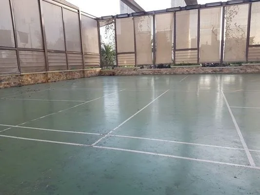 Una cancha exterior cercada con líneas pintadas.