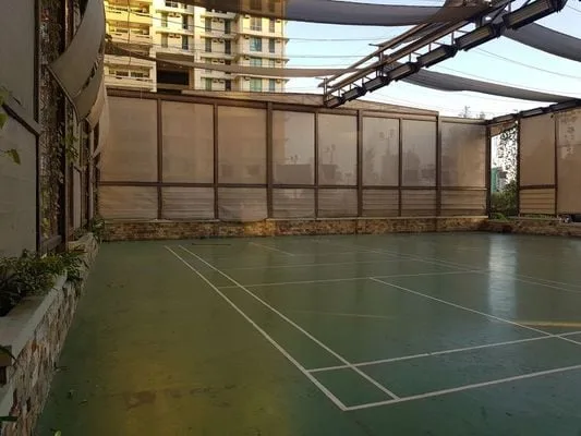 Una cancha deportiva cubierta tiene piso verde con líneas blancas.