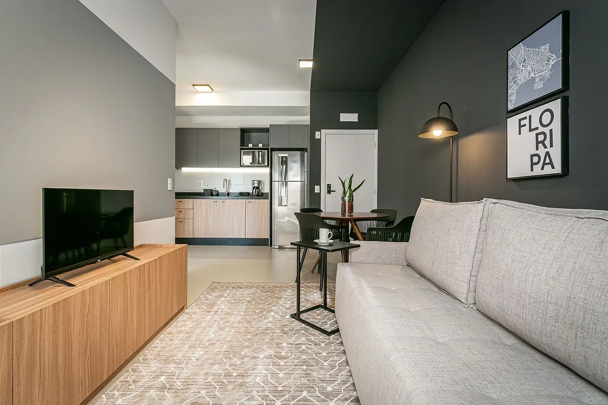 An open-plan living area with a seating area, television, and kitchen.