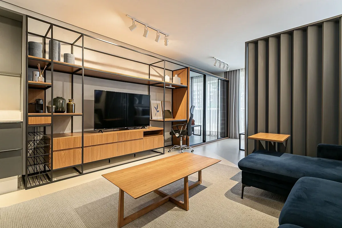 A modern living room with open shelving, a television, and seating.