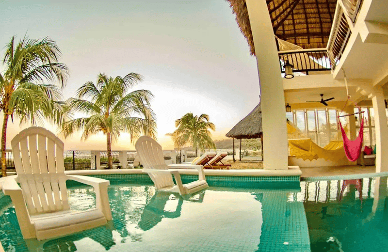 Piscina, palmeras y hamaca en una casa vacacional frente a la playa en Playa Guasacate, Popoyo, Nicaragua