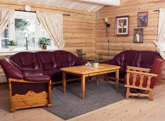 A wood-paneled living room with burgundy seating around a coffee table.