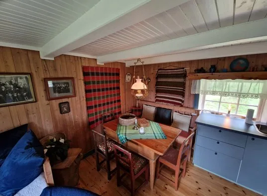 A wood-paneled dining area with a table and seating beside a window.