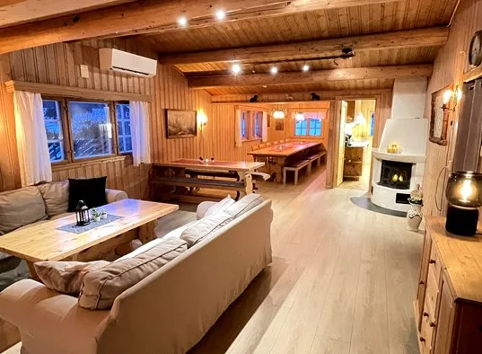 Una sala de estar y comedor revestida de madera, con asientos alrededor de una mesa.