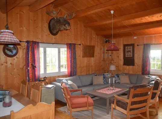 A wood-paneled living room with seating arranged around a coffee table.