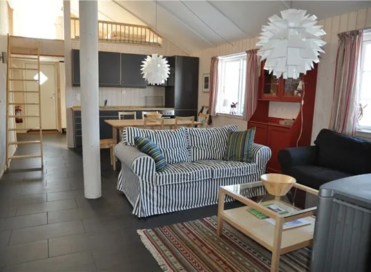 A living area with striped seating, a coffee table, and a dining space.