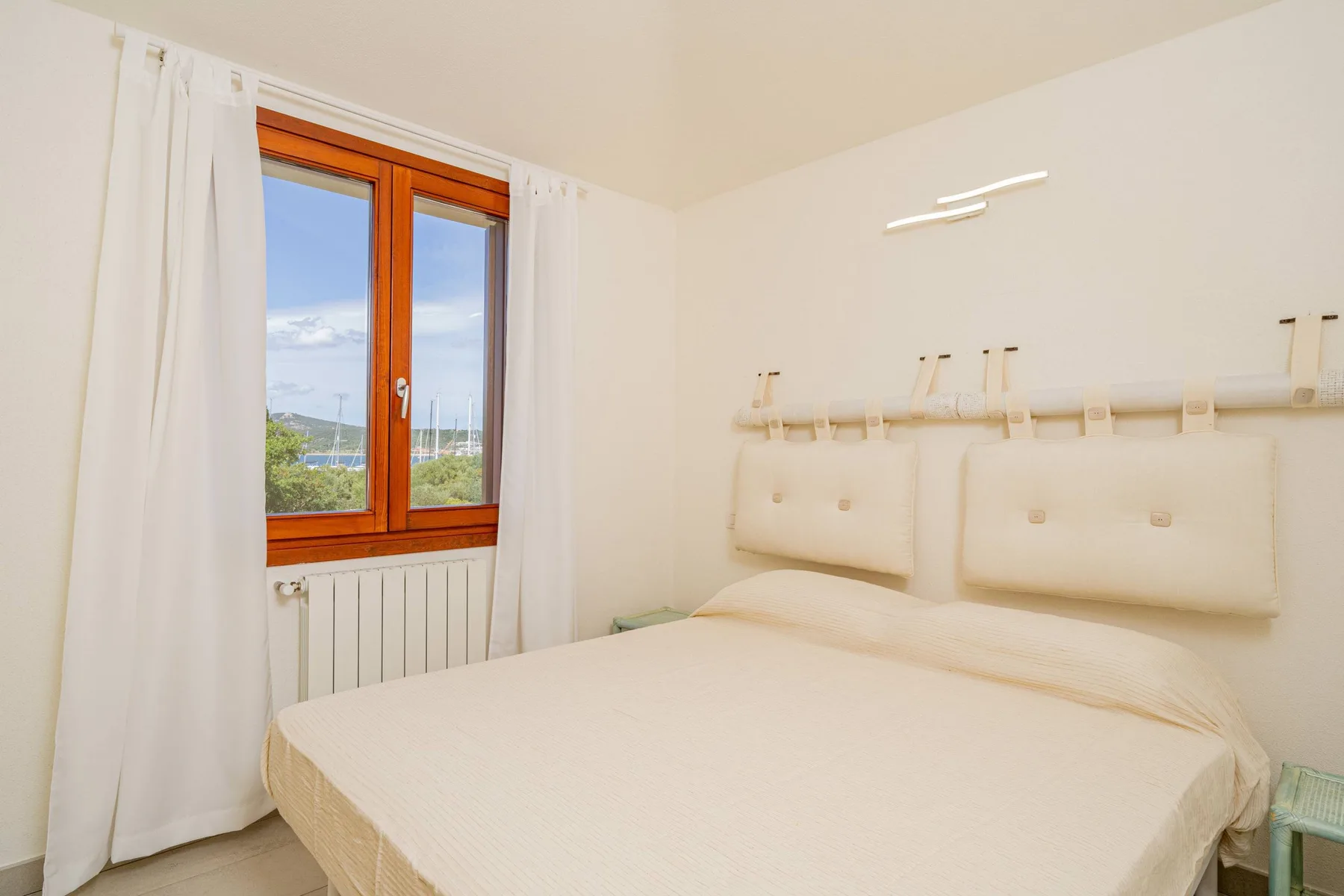 Un dormitorio con una cama junto a una ventana con cortinas.