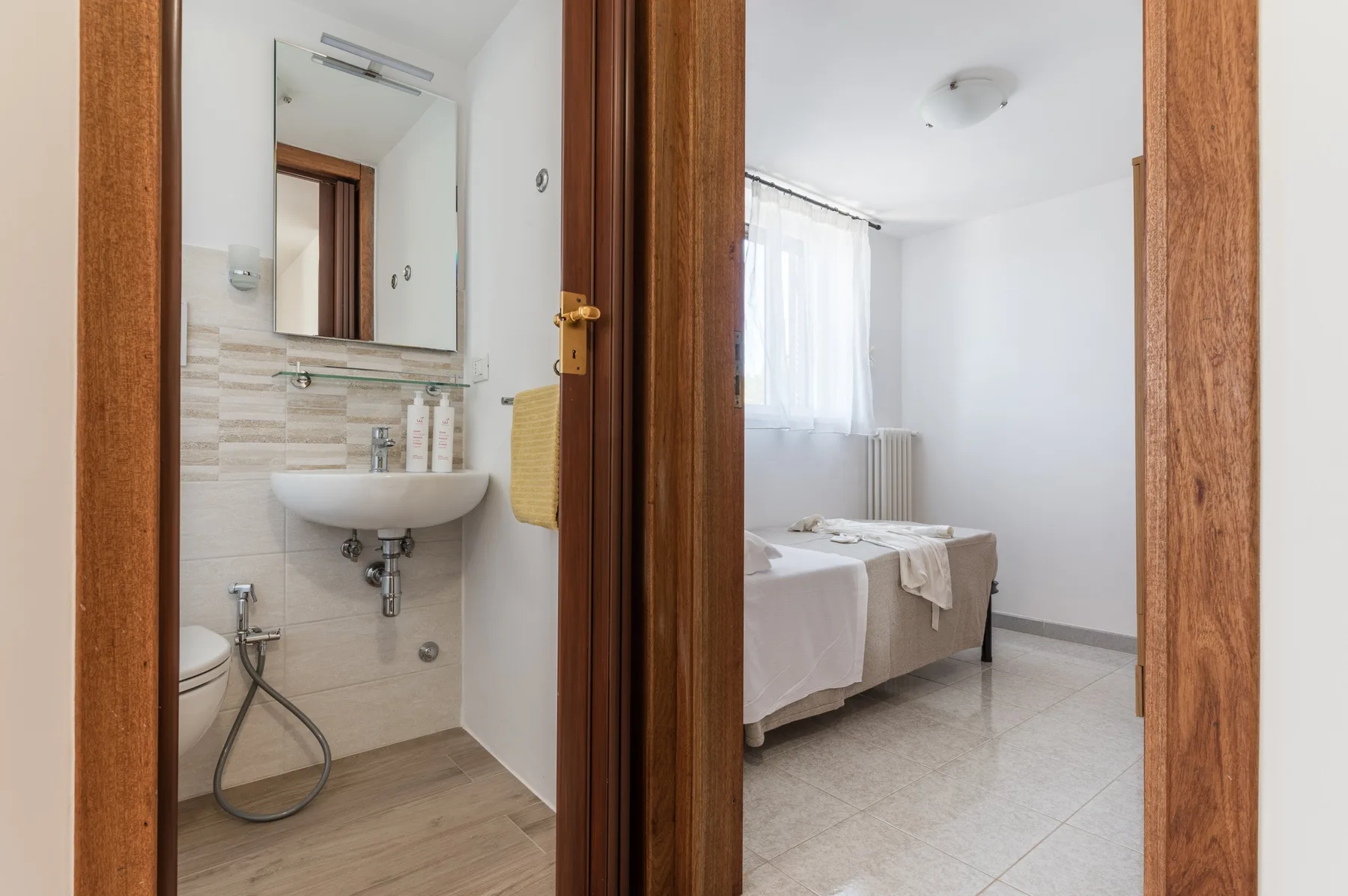A bathroom and bedroom are visible through adjoining doorways.