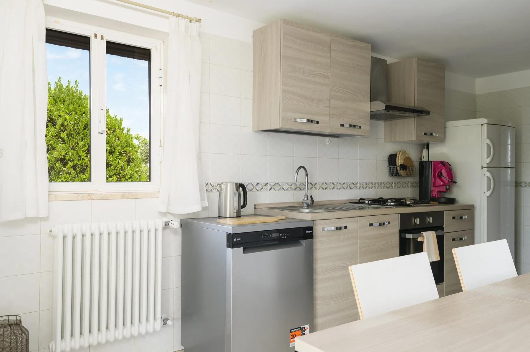 A bright kitchen with a window, countertop, sink, and cooking appliances.