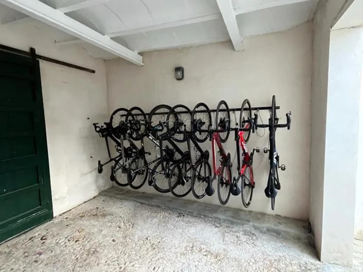 Una zona cubierta para guardar bicicletas, con varias bicicletas en un soporte.