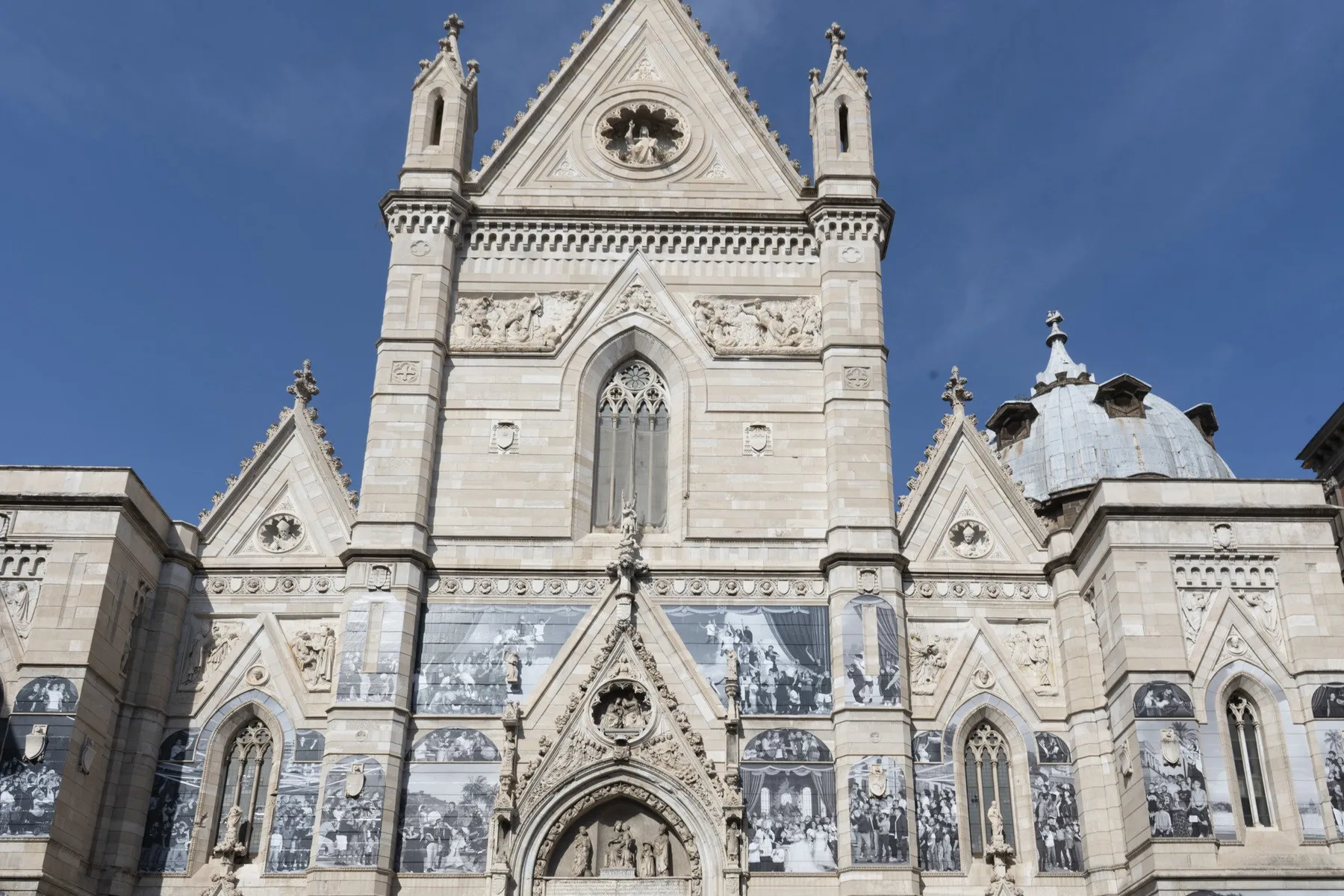 An ornate stone church facade with pointed arches and decorative panels.