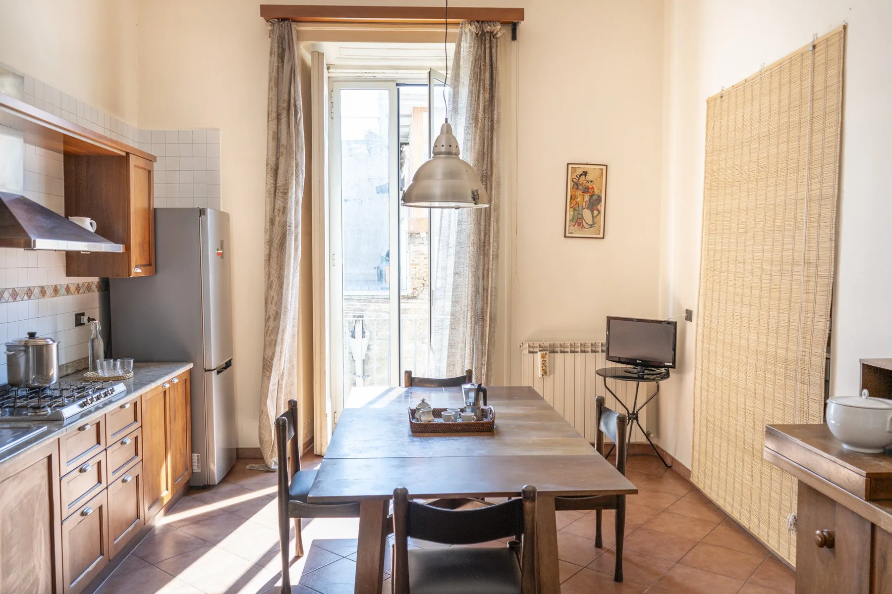 Comedor con una mesa de madera, junto a una cocina compacta.