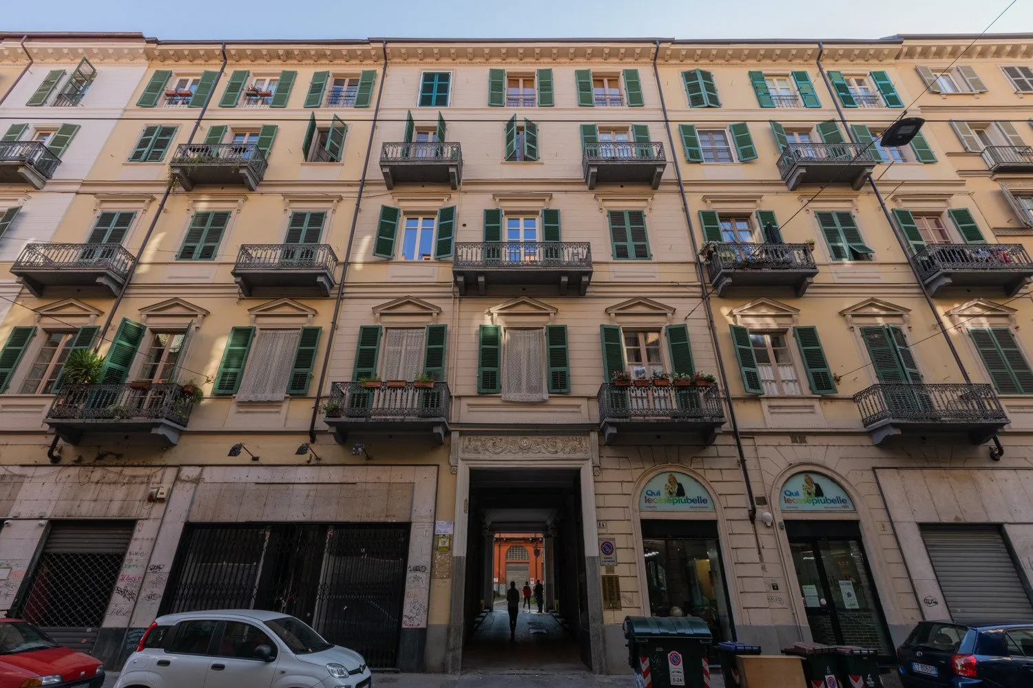 A multi-story building facade with rows of windows and small balconies.