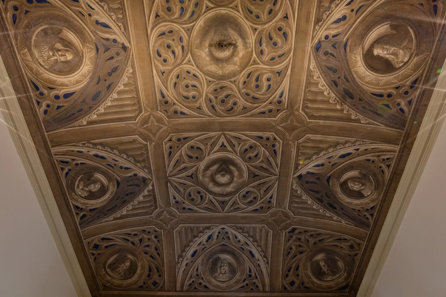 Un techo ornamentado con medallones circulares repetidos y detalles azules.