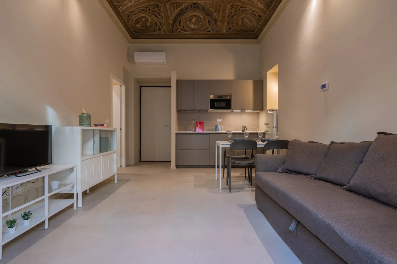 Una sala de estar se abre a una cocina compacta, con una mesa de comedor entre ambas.