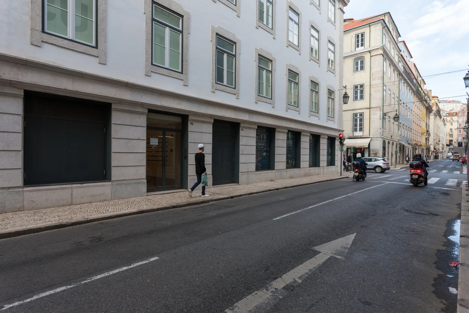 Una calle urbana flanqueada por edificios de varias plantas y tráfico.