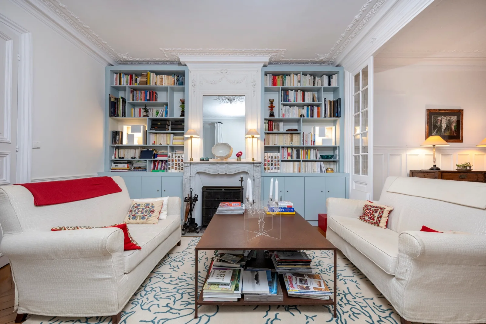 A bright living room with two sofas, built-in bookshelves, and a central coffee table.