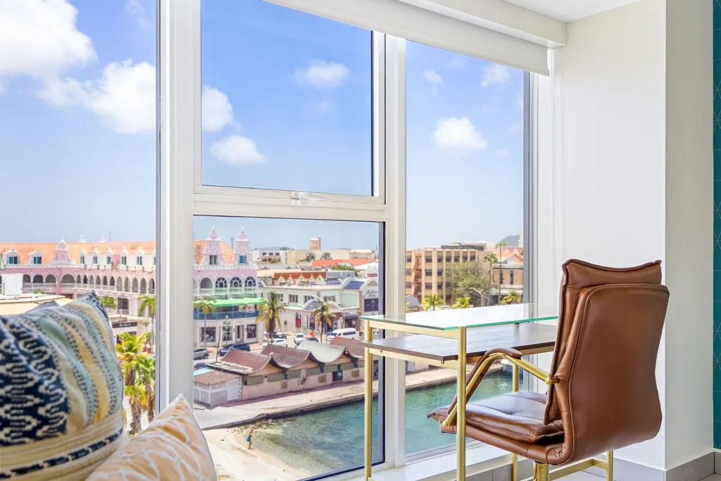Bright city views frame this inviting seating area, where waterfront scenery and colorful architecture create a vibrant backdrop for relaxing mornings or peaceful afternoons in your vacation rental.