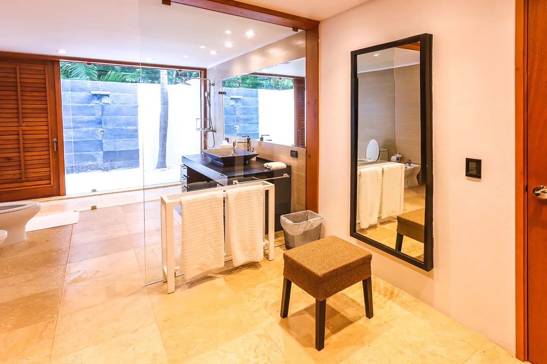 Un baño con lavabo, toallas y un espejo grande en la pared.