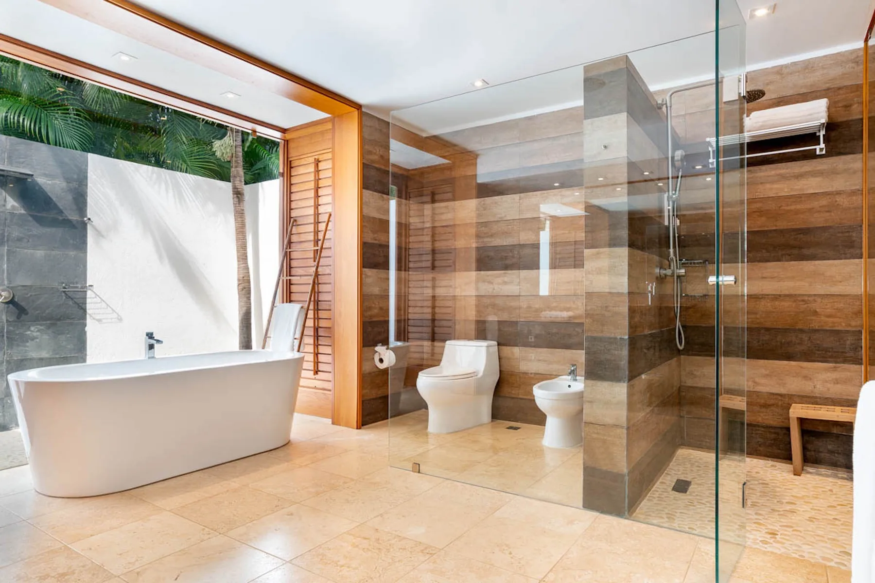 Un baño amplio con bañera, inodoro y ducha con mampara de vidrio.