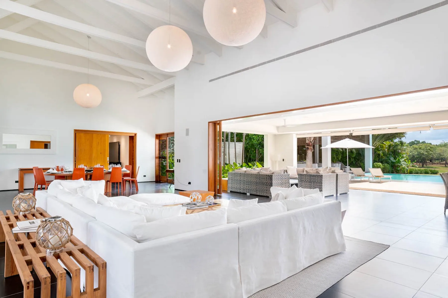 Una luminosa sala de estar y comedor de planta abierta da a un patio junto a la piscina.