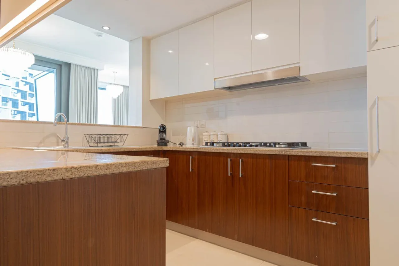 Una cocina moderna con gabinetes de madera oscura, encimera y estufa.