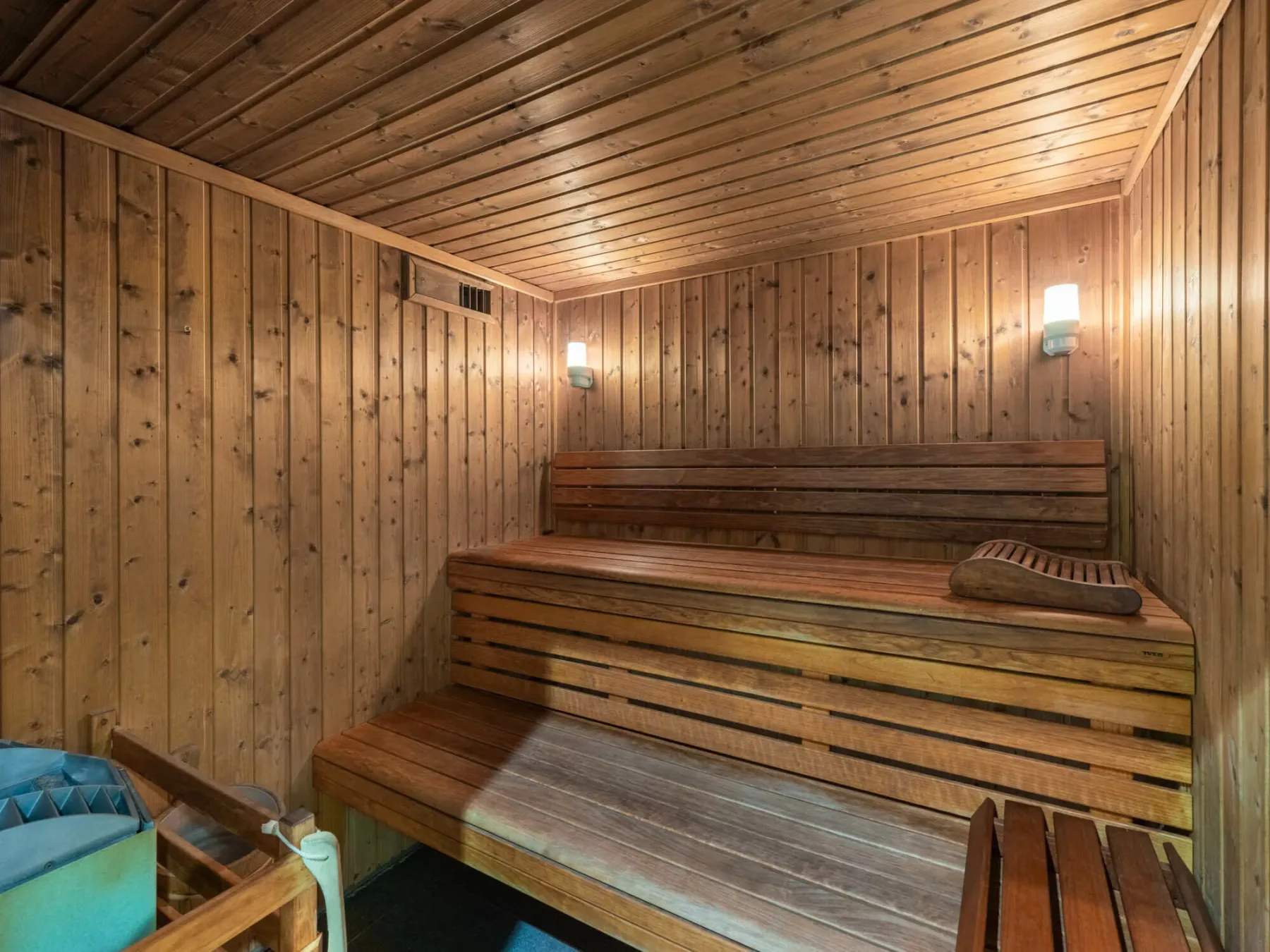 Una sauna revestida de madera con asientos escalonados y luces en la pared.