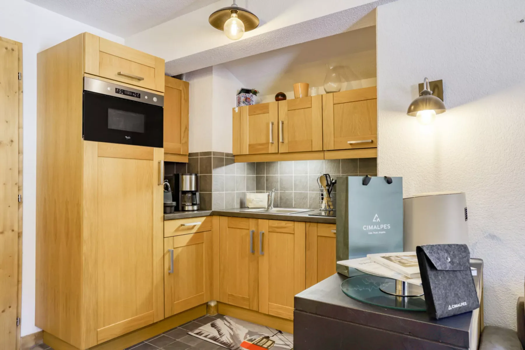 A compact kitchen with wooden cabinets, a built-in microwave, and a tiled backsplash.