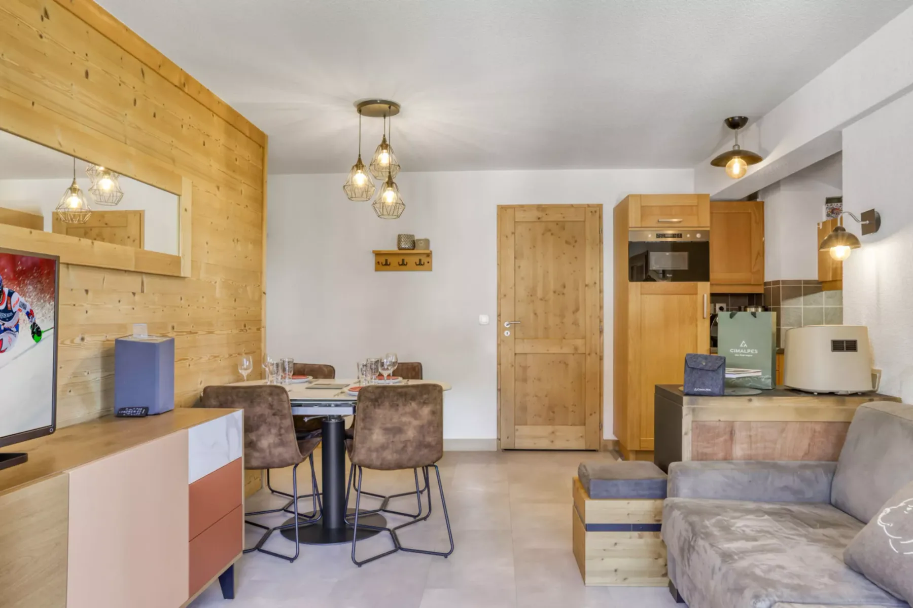 Zona de estar y comedor con asientos, una mesa y una cocina compacta.