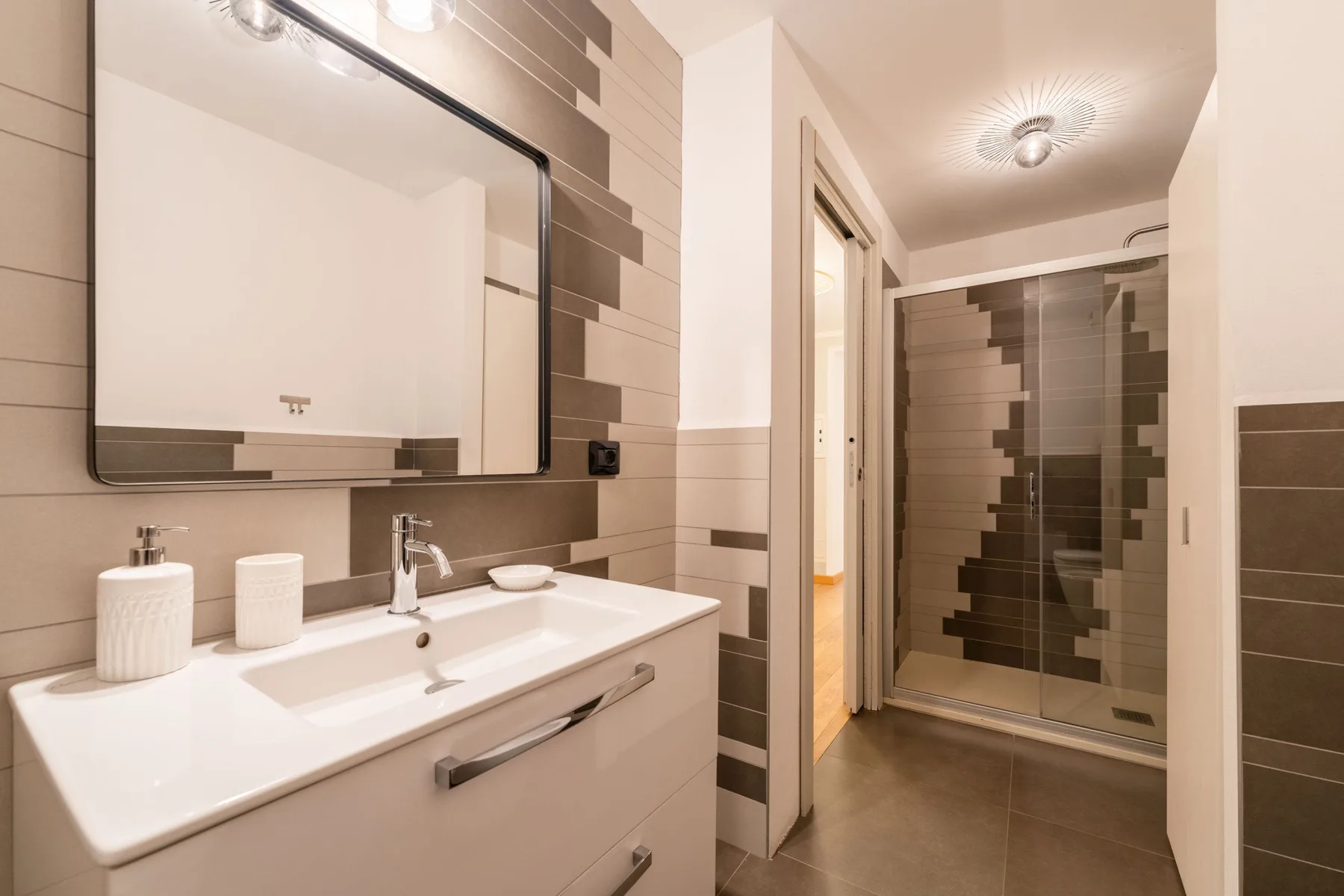 Un baño con lavabo y una ducha de vidrio.