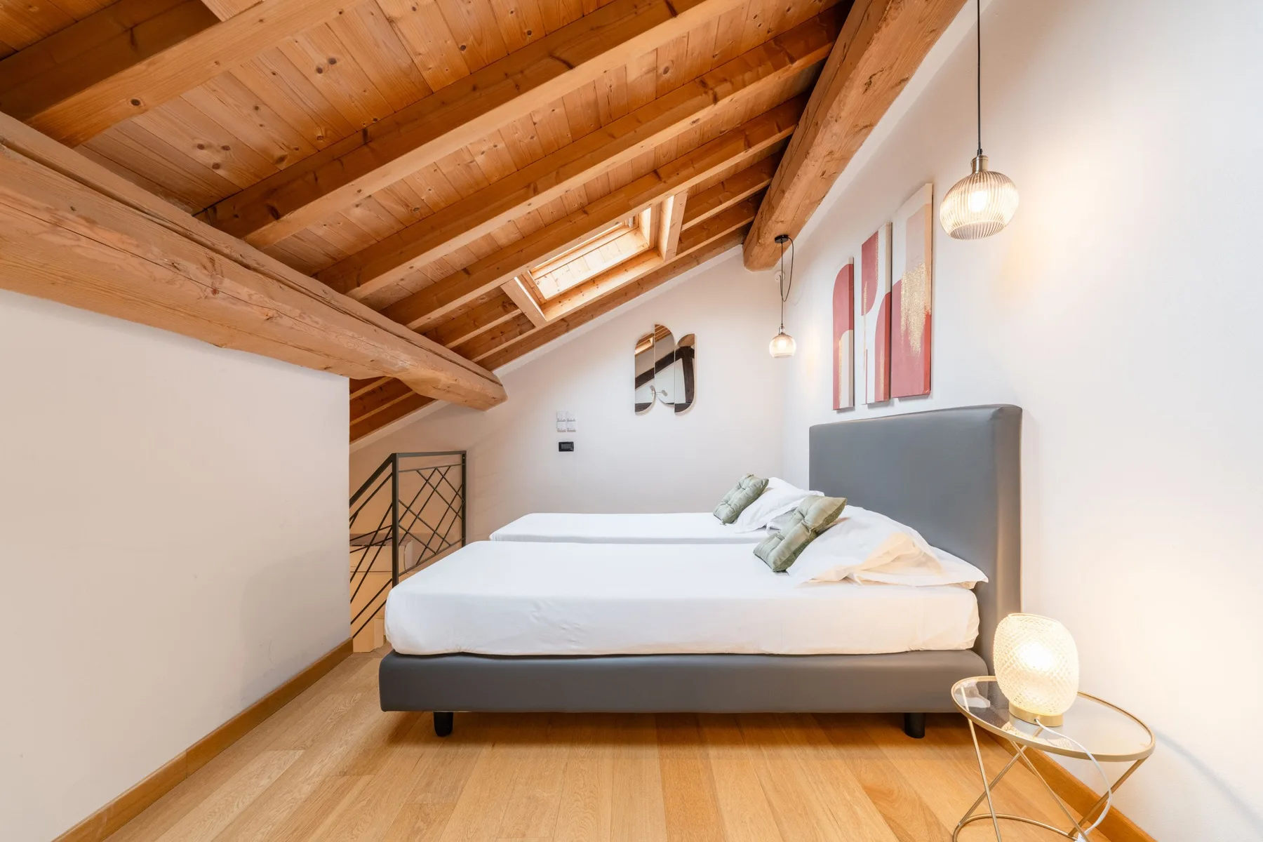 Un dormitorio con una cama bajo un techo inclinado de madera.