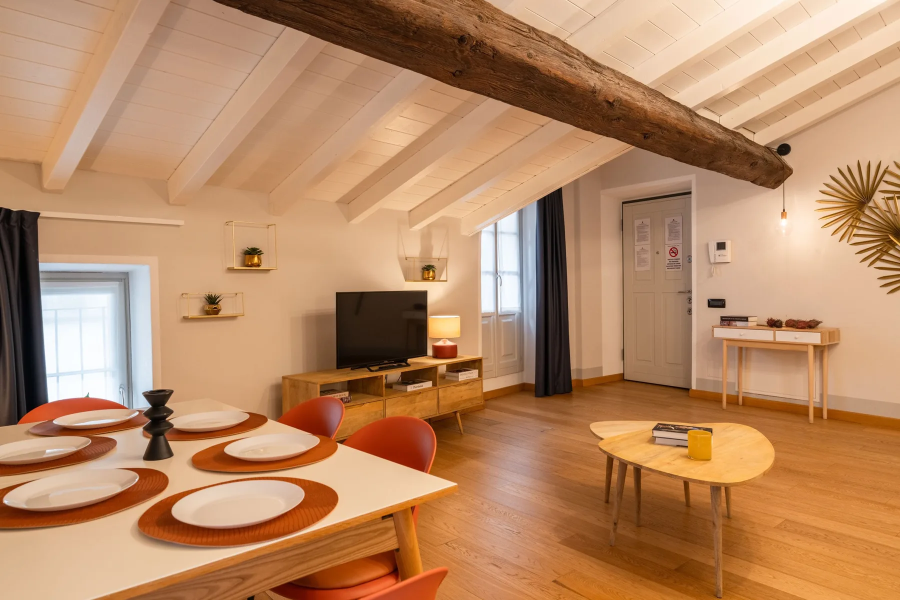 Una sala de estar y comedor con televisión, mesa de comedor y mesa de centro.
