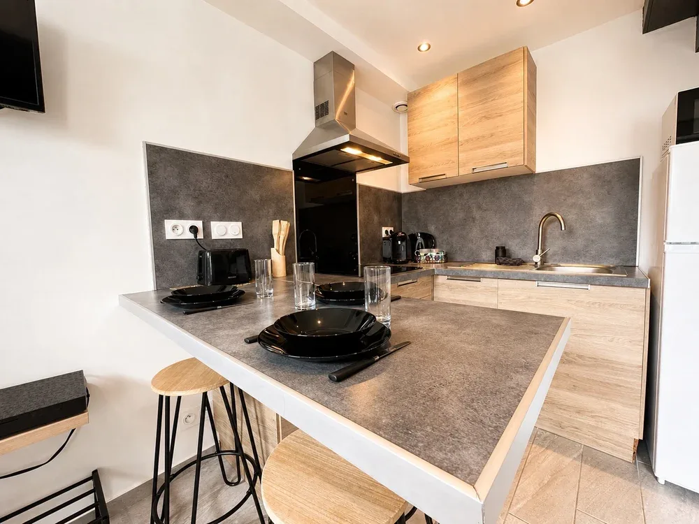 A modern kitchen with a broad island and wooden cabinets.