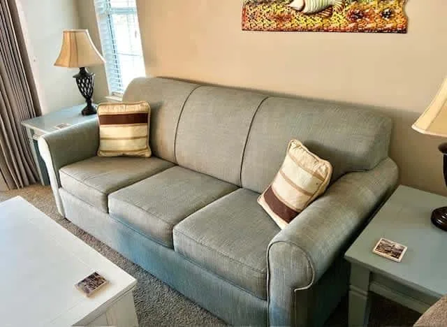A living room with a gray sofa and side tables.