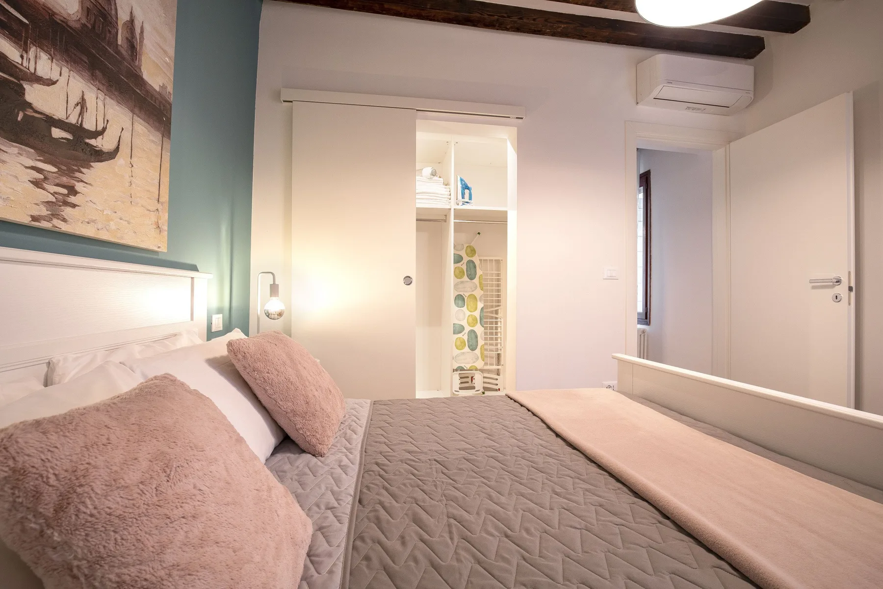 Un dormitorio con una cama bien hecha y almacenamiento empotrado.