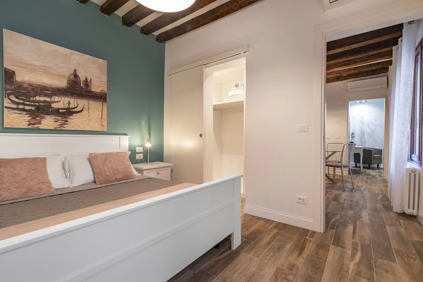 Un dormitorio con una cama y una puerta abierta que da a otra habitación.