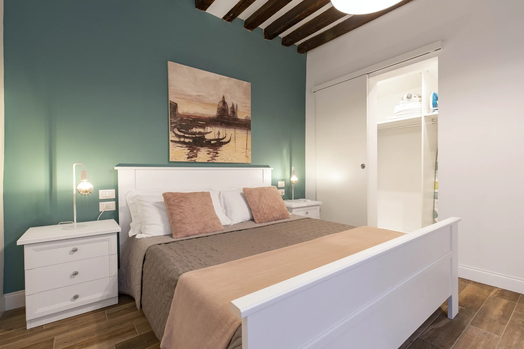 Un dormitorio con una cama, mesitas de noche y una pared verde.