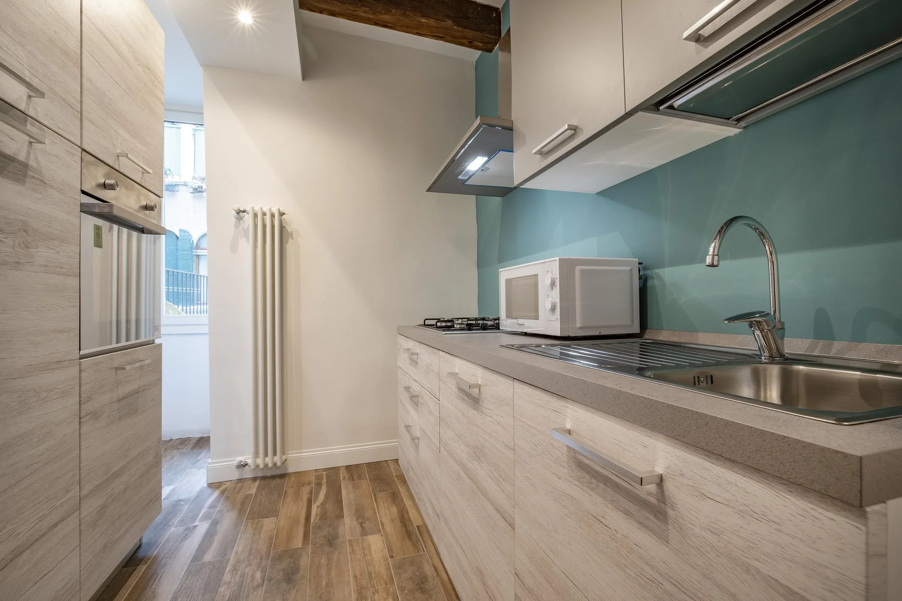 Una cocina moderna con gabinetes claros, una encimera y un fregadero.