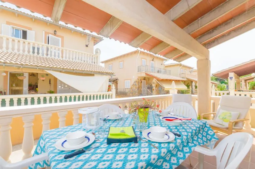 Comedor exterior cubierto con mantel estampado y asientos de patio.