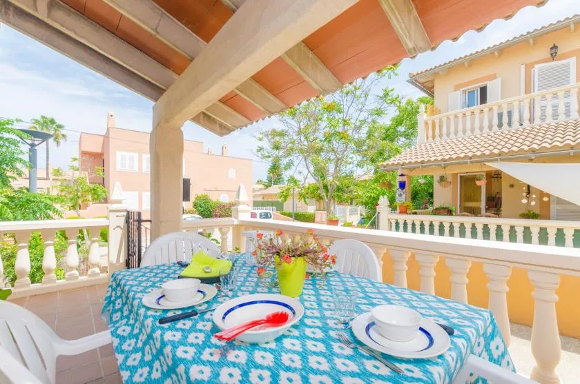 Una terraza exterior cubierta con una mesa preparada para comer.