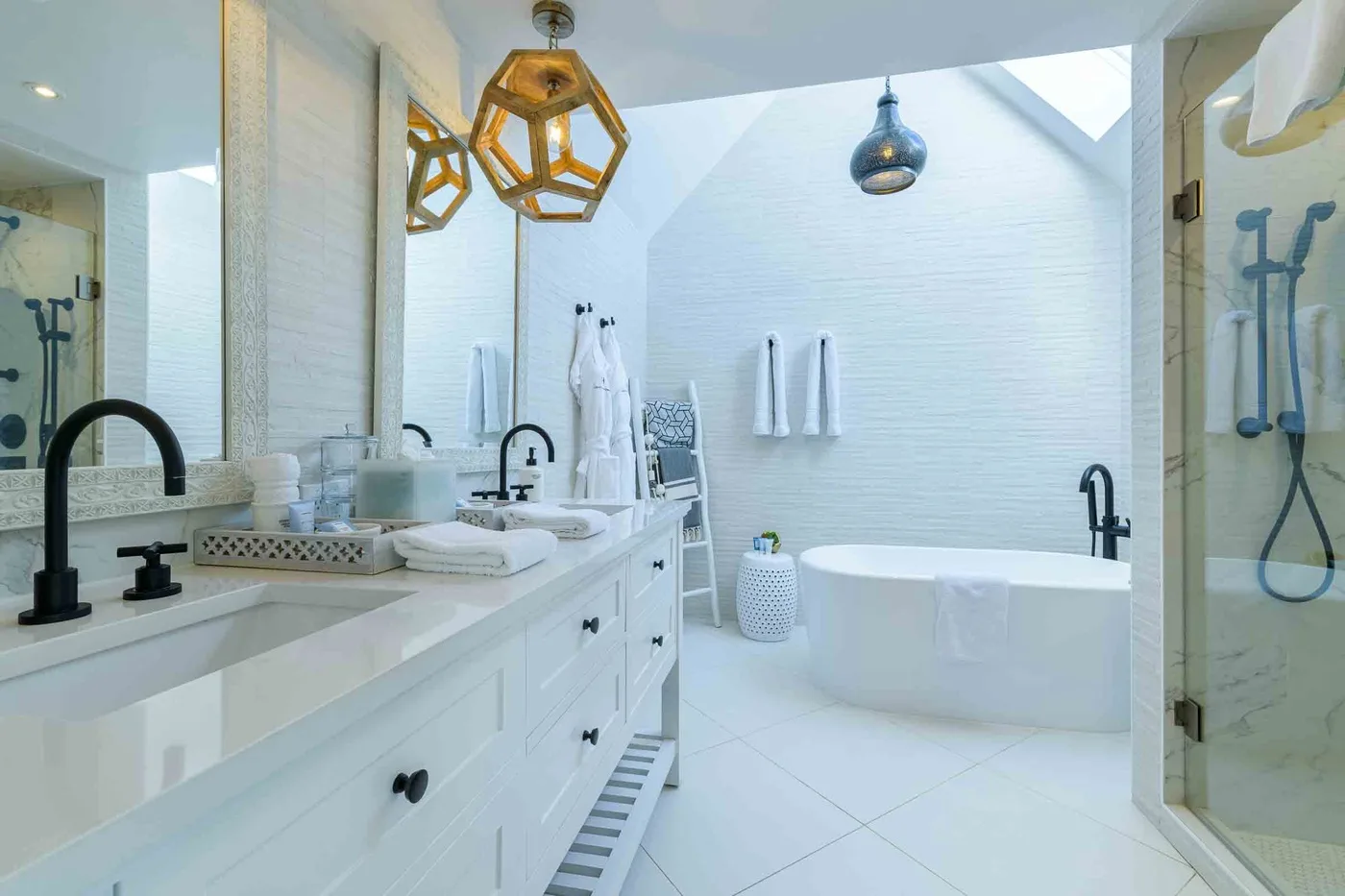 Un baño luminoso con bañera blanca, lavabo y ducha de vidrio.