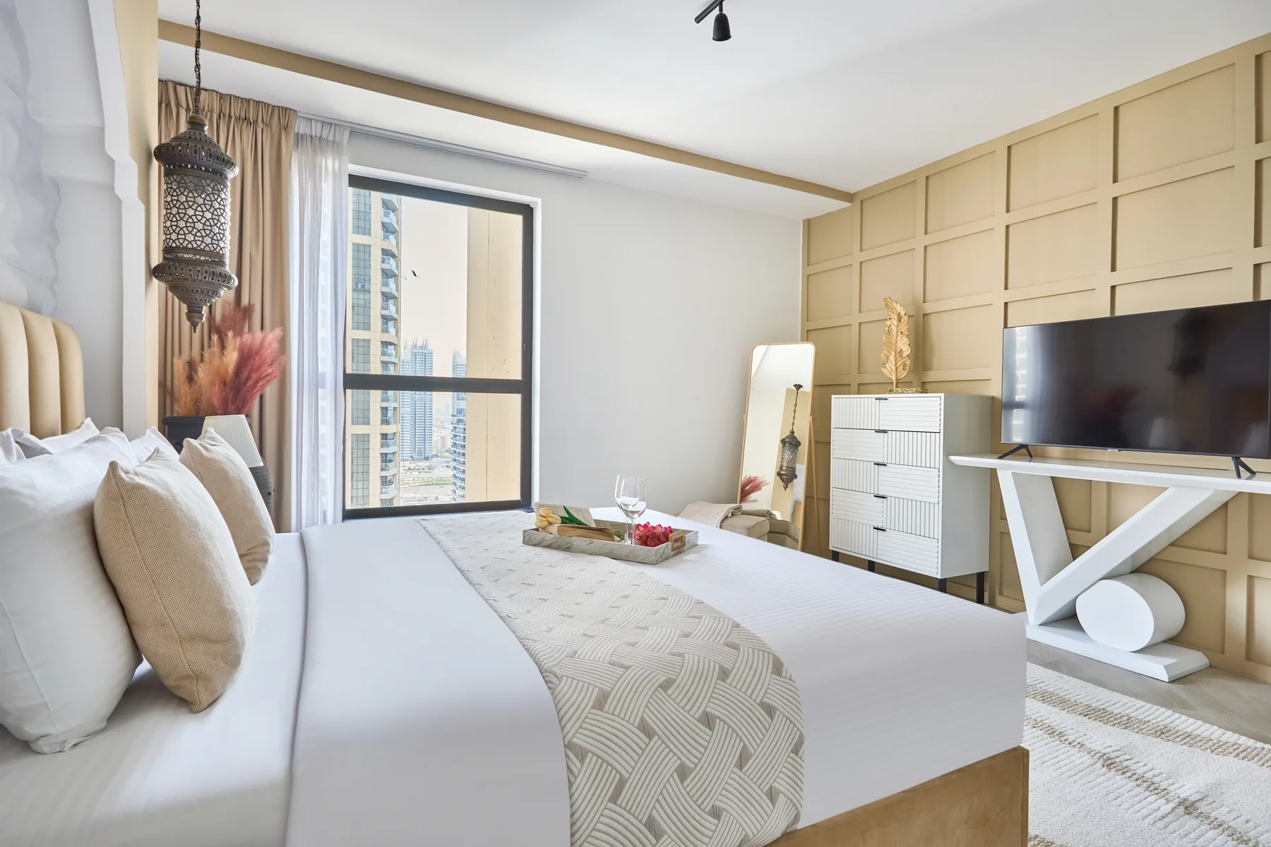 Un dormitorio luminoso con una cama grande, paneles decorativos en la pared y un televisor.
