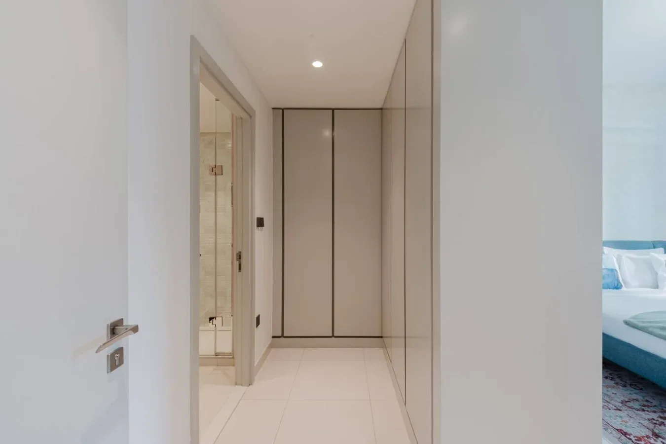 Un pasillo interior luminoso con una puerta que da a un dormitorio.