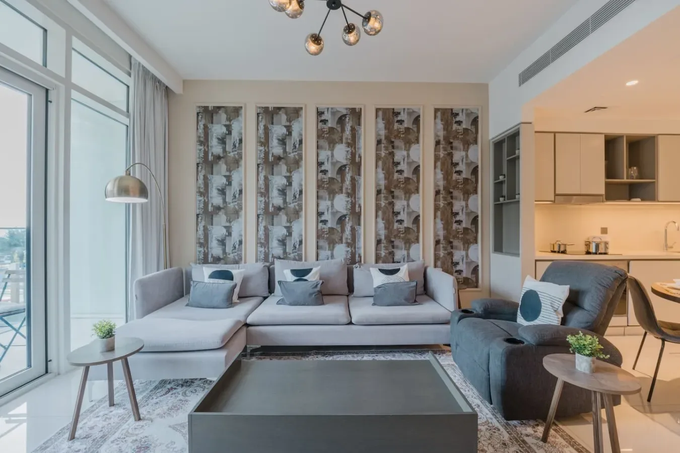 A bright living room has sectional seating, a coffee table, and tall windows.