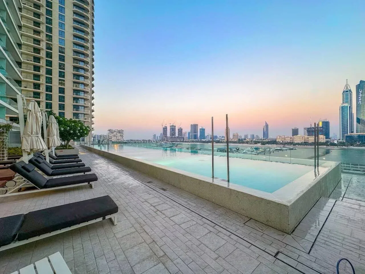 Una piscina en la azotea mira al horizonte de la ciudad, con asientos junto a la terraza.
