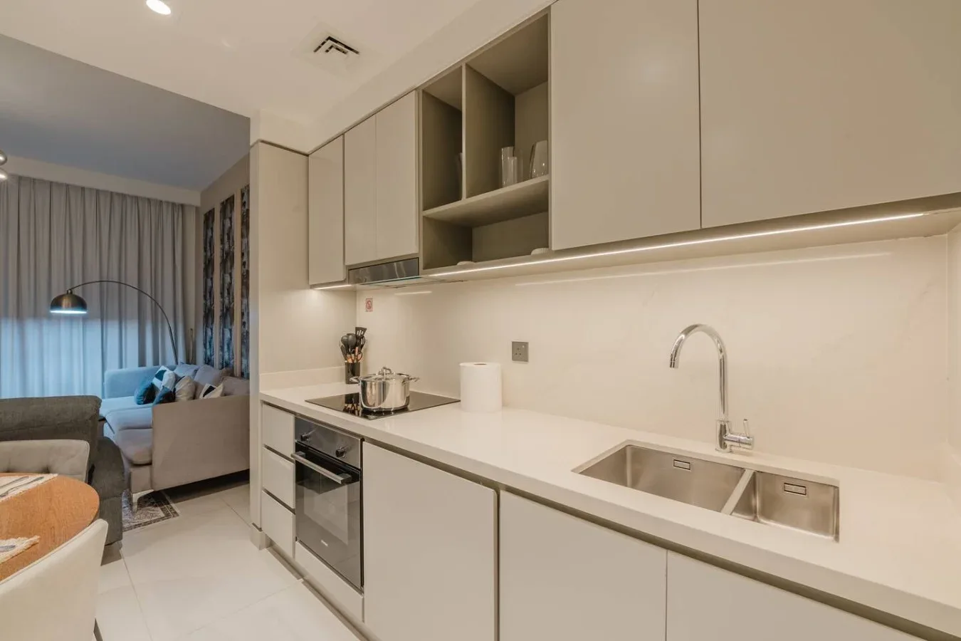 Una cocina moderna con gabinetes claros, un fregadero y una estufa.
