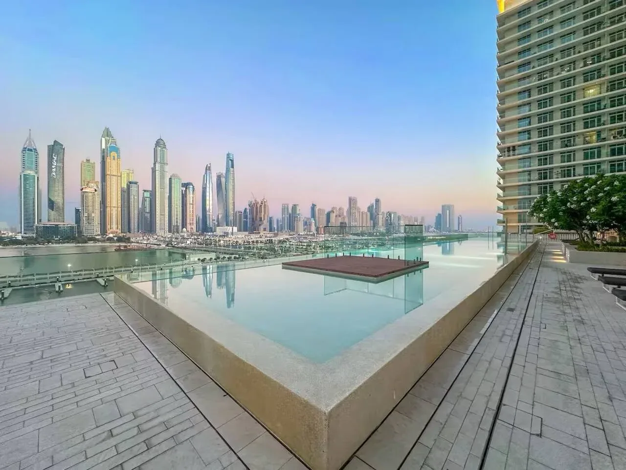 Una terraza en la azotea da a un estanque reflectante y un horizonte urbano.