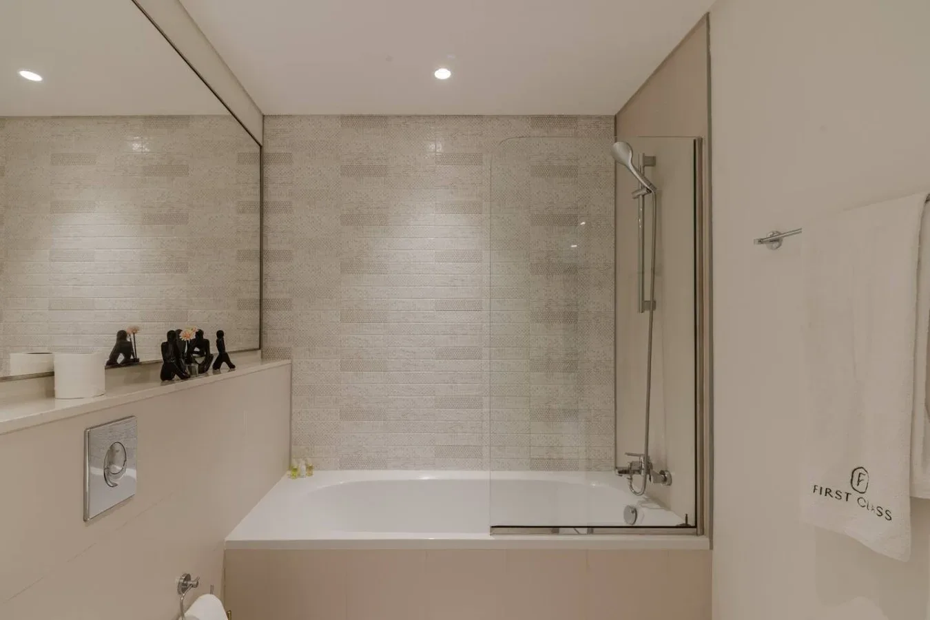Un baño alicatado con bañera, ducha y encimera de lavabo.