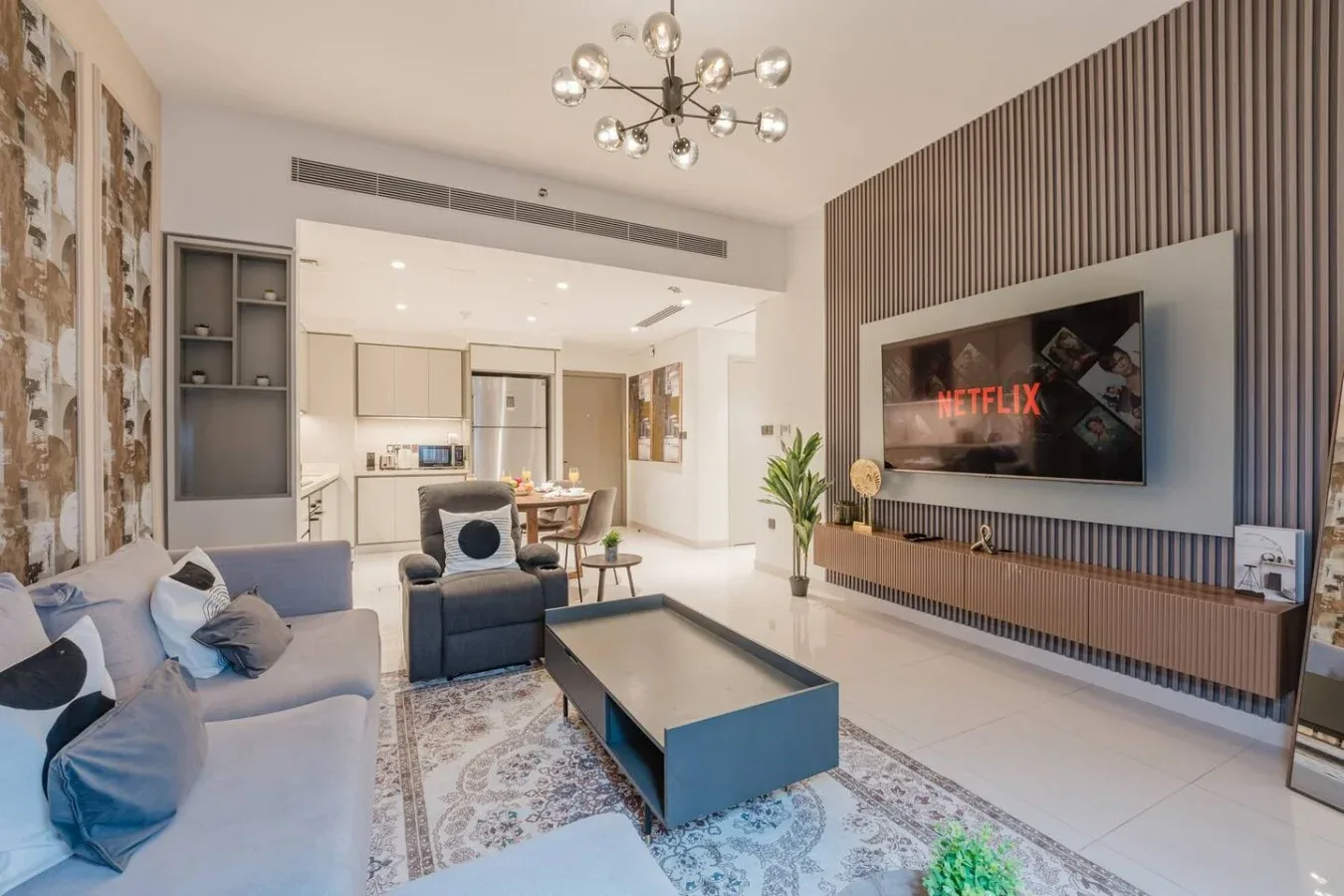 Una sala de estar moderna con asientos, una mesa de centro y un televisor en la pared.