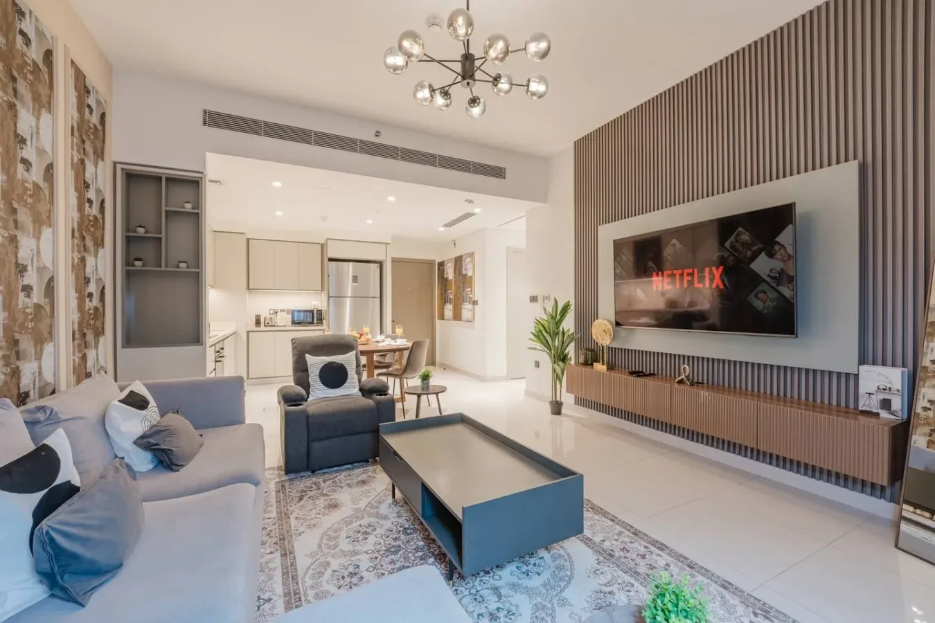 Una sala de estar moderna con asientos, una mesa de centro y un televisor en la pared.